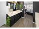 Chic bathroom features dual sinks, wood-look flooring, dark walls, and decorative plants at 10909 W Chase Ln, Avondale, AZ 85323