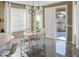 Bright dining area with modern light fixture, and a sliding glass door with plantation shutters at 10909 W Chase Ln, Avondale, AZ 85323