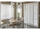 Bright dining area with modern light fixture, and a sliding glass door with plantation shutters at 10909 W Chase Ln, Avondale, AZ 85323