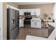 Well-lit kitchen features stainless steel appliances, white cabinets, modern fixtures, and speckled white countertops at 10909 W Chase Ln, Avondale, AZ 85323
