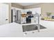 Well-lit kitchen features stainless steel appliances, white cabinets, modern fixtures, and speckled white countertops at 10909 W Chase Ln, Avondale, AZ 85323