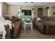 Cozy living room with tile flooring, comfortable seating, and a modern entertainment center, perfect for relaxing and entertaining at 10909 W Chase Ln, Avondale, AZ 85323