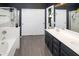 Stylish bathroom boasts dual sinks, updated vanity, tub, and sliding door access to toilet at 10909 W Chase Ln, Avondale, AZ 85323