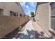 Narrow walkway between homes shows the clean landscape with easy access to the backyard at 10909 W Chase Ln, Avondale, AZ 85323