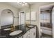 Bathroom featuring double vanity sinks, black marble countertop, and tiled shower/tub at 11049 N 111Th Way, Scottsdale, AZ 85259