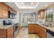 Well-lit kitchen featuring stainless steel appliances, granite countertops, and wood cabinetry at 11049 N 111Th Way, Scottsdale, AZ 85259