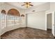Bright living room with wood floors and arched windows with wood blinds at 11049 N 111Th Way, Scottsdale, AZ 85259