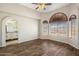 Bright living room with wood floors, arched windows with wood blinds and a ceiling fan at 11049 N 111Th Way, Scottsdale, AZ 85259