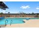 Community pool with desert-style landscaping, lounge seating, and adjacent dining areas at 11553 W Cottontail Ct, Surprise, AZ 85378