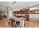 Modern kitchen with granite countertops, stainless steel appliances, dark wood cabinetry and four bar stools at 11553 W Cottontail Ct, Surprise, AZ 85378