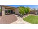 Cozy backyard with patio, artificial grass, desert landscaping, and a sliding glass door at 12083 W Peak View Rd, Peoria, AZ 85383