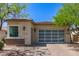 Single-story home with a glass paneled garage door and desert landscaping at 12083 W Peak View Rd, Peoria, AZ 85383
