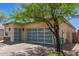 Single-story home featuring a glass paneled garage door and desert landscaping at 12083 W Peak View Rd, Peoria, AZ 85383