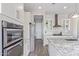 Modern kitchen showcasing built-in ovens, stainless steel appliances, and sleek white cabinetry at 12083 W Peak View Rd, Peoria, AZ 85383