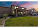 This backyard features a manicured lawn, gravel landscaping, outdoor kitchen and a covered patio at 12238 W Patrick Ct, Sun City, AZ 85373