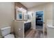 Bathroom with dual vanities, wood accent wall with open access to bedroom at 12238 W Patrick Ct, Sun City, AZ 85373