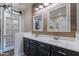 Bathroom featuring dual sinks, wood accent wall and a sliding door at 12238 W Patrick Ct, Sun City, AZ 85373