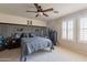 Bedroom with paneled accent wall, ceiling fan, and natural light at 12238 W Patrick Ct, Sun City, AZ 85373