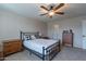 Comfortable bedroom featuring a metal frame bed, ceiling fan, and neutral color scheme, creating a relaxing ambiance at 12238 W Patrick Ct, Sun City, AZ 85373