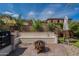 An outdoor fire pit and bench seating offer a cozy backyard experience with lush, mature landscaping at 12238 W Patrick Ct, Sun City, AZ 85373