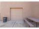 Beige garage door next to picnic table and trash can on the side of the home at 12238 W Patrick Ct, Sun City, AZ 85373