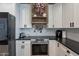 Kitchen with white cabinets, black countertops, stainless steel range, and decorative patriotic decor at 12238 W Patrick Ct, Sun City, AZ 85373
