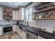 Bright kitchen with white cabinets, stainless steel sink, and open shelving at 12238 W Patrick Ct, Sun City, AZ 85373