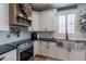 A kitchen featuring white cabinets, black countertops, and stainless steel appliances at 12238 W Patrick Ct, Sun City, AZ 85373
