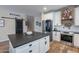 Kitchen with island, stainless steel appliances, white cabinets, and wood floors at 12238 W Patrick Ct, Sun City, AZ 85373
