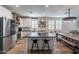 Spacious kitchen featuring an island, bar stools, stainless steel appliances, and wood floors at 12238 W Patrick Ct, Sun City, AZ 85373