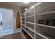 Well-organized laundry room with open shelving for linens and cleaning supplies at 12238 W Patrick Ct, Sun City, AZ 85373