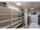 Bright laundry room featuring extensive shelving for storage, plus modern washer dryer at 12238 W Patrick Ct, Sun City, AZ 85373