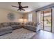 Cozy living room with neutral tones, ceiling fan, and access to the backyard at 12238 W Patrick Ct, Sun City, AZ 85373