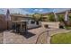 Paver patio features a built-in outdoor kitchen, bar, seating, fire pit, gravel landscaping and a small grass lawn at 12238 W Patrick Ct, Sun City, AZ 85373