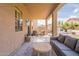 Inviting covered patio with comfortable seating, an outdoor kitchen, and stylish decor at 12238 W Patrick Ct, Sun City, AZ 85373