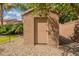 A neutral color storage shed sits among gravel landscaping and tropical trees at 12238 W Patrick Ct, Sun City, AZ 85373