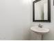 Simple half-bathroom featuring a pedestal sink and decorative mirror at 13380 N 148Th Ave, Surprise, AZ 85379