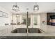 Contemporary kitchen featuring granite countertops and stainless steel sink, and modern pendant lighting at 13380 N 148Th Ave, Surprise, AZ 85379