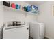 Efficient laundry room featuring modern washer and dryer units with overhead shelving at 13380 N 148Th Ave, Surprise, AZ 85379