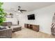 Cozy living room with a plush sectional sofa, ceiling fan, and a modern media console at 13380 N 148Th Ave, Surprise, AZ 85379