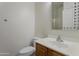 Half bath with decorative framed mirror above a vanity cabinet and toilet at 15240 N 142Nd Ave # 2171, Surprise, AZ 85379