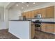 Bright kitchen features stainless steel appliances, light wood cabinets, and a breakfast bar at 15240 N 142Nd Ave # 2171, Surprise, AZ 85379