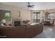 Spacious living room featuring a large leather couch, fireplace, and ceiling fan for comfortable living at 15252 N 100Th St # 1172, Scottsdale, AZ 85260