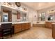 This spacious bathroom features double sinks, vanity lighting, a jetted tub, and a glass-enclosed shower at 15416 W Valentine St, Surprise, AZ 85379