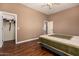 Bedroom featuring wood floor, comfortable bed, closet, ceiling fan and direct access to the bathroom at 15416 W Valentine St, Surprise, AZ 85379