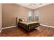 Bedroom features wood flooring, neutral walls, two windows and a comfortable bed at 15416 W Valentine St, Surprise, AZ 85379