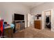 Bedroom with large TV features carpet, neutral walls, access to the bathroom and walk-in closet at 15416 W Valentine St, Surprise, AZ 85379