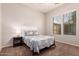 Bright bedroom features carpet, neutral walls, a window and a comfortable bed with side table at 15416 W Valentine St, Surprise, AZ 85379