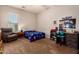 Bedroom features carpet, window, ceiling fan, and study area, creating a flexible living space at 15416 W Valentine St, Surprise, AZ 85379