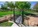 Beautiful community park featuring a metal bridge, playground, and lush greenery for enjoyment at 15416 W Valentine St, Surprise, AZ 85379